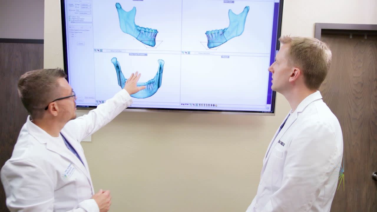 Dr. Bryan and Dr. Goodson examine a 3D scan of a jaw for dental implants