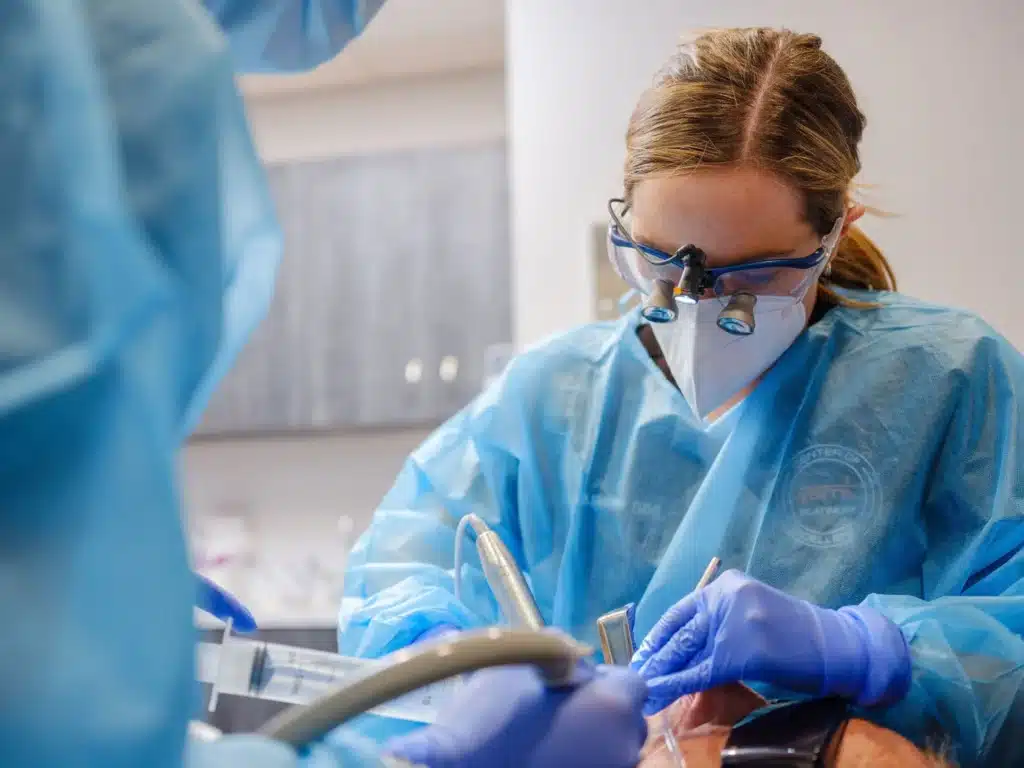 A close-up view of oral surgeon Dr. Amanda E. Suits performing a surgical procedure on a patient